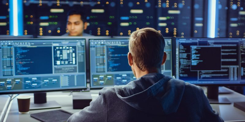 IT professional monitors multiple screens in a secure environment, symbolizing managed services and VMS implementation for biopharma workforce optimization