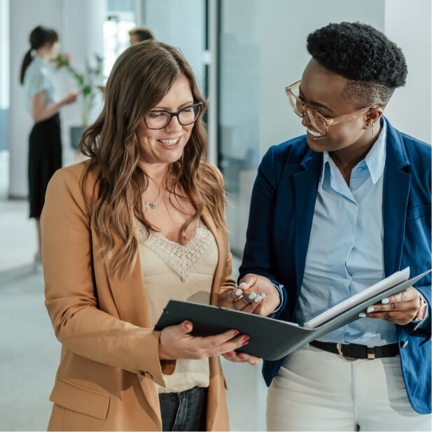 Two professionals discussing workforce solutions and reviewing documents in an office